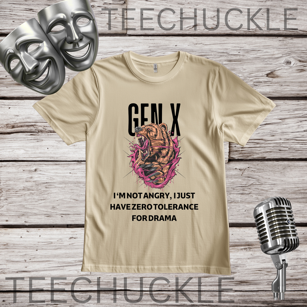 A sand graphic t-shirt displayed on a rustic wood background, featuring a roaring bear illustration and the text 'GEN X I'M NOT ANGRY, I JUST HAVE ZERO TOLERANCE FORDRAMA'. The shirt is styled with two silver theater masks, a vintage microphone