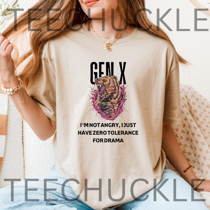 A woman wearing a sand graphic t-shirt with a Gen X themed bear design and text, sitting in a cozy indoor setting. The t-shirt features a tiger illustration inside a pink circular frame with the text 'GEN X I'M NOT ANGRY, I JUST HAVE ZERO TOLERANCE FOR DRAMA'.