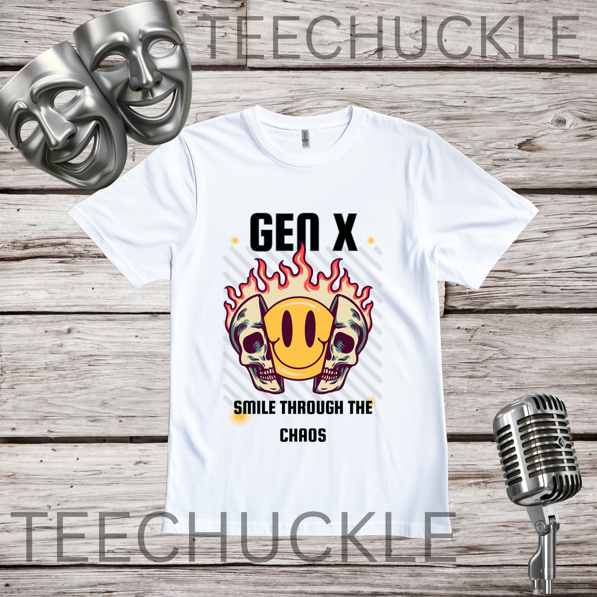 A white graphic t-shirt displayed on a rustic wood background, featuring a design with two skulls in flames and a yellow smiley face. The text reads 'GEN X SMILE THROUGH THE CHAOS', in the corners are comedy masks and a vintage microphone.