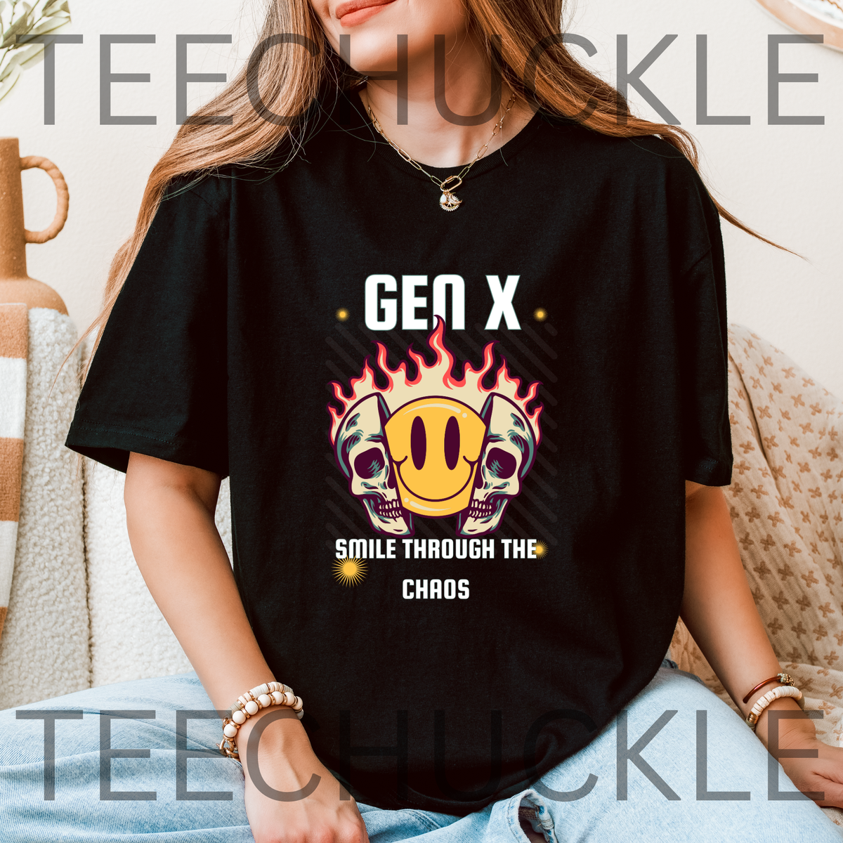A woman wearing a black graphic T-shirt with a 'Gen X Smile Through The Chaos' design featuring skulls, a smiley face, and flames. 