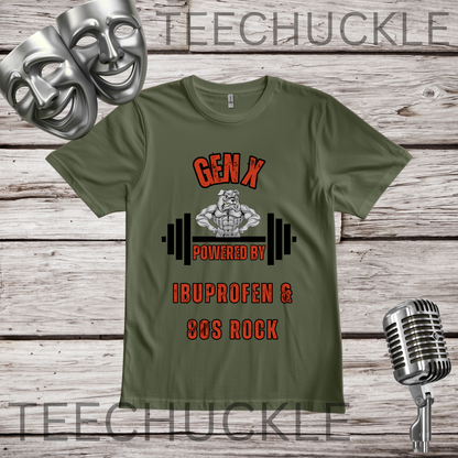 A green graphic t-shirt displayed on a rustic wood background, featuring a design with two silver comedy masks, a vintage microphone, and the text 'GEN X POWERED BY IBUPROFEN & 80S ROCK' with a muscular bulldog cartoon character and barbell graphic. 