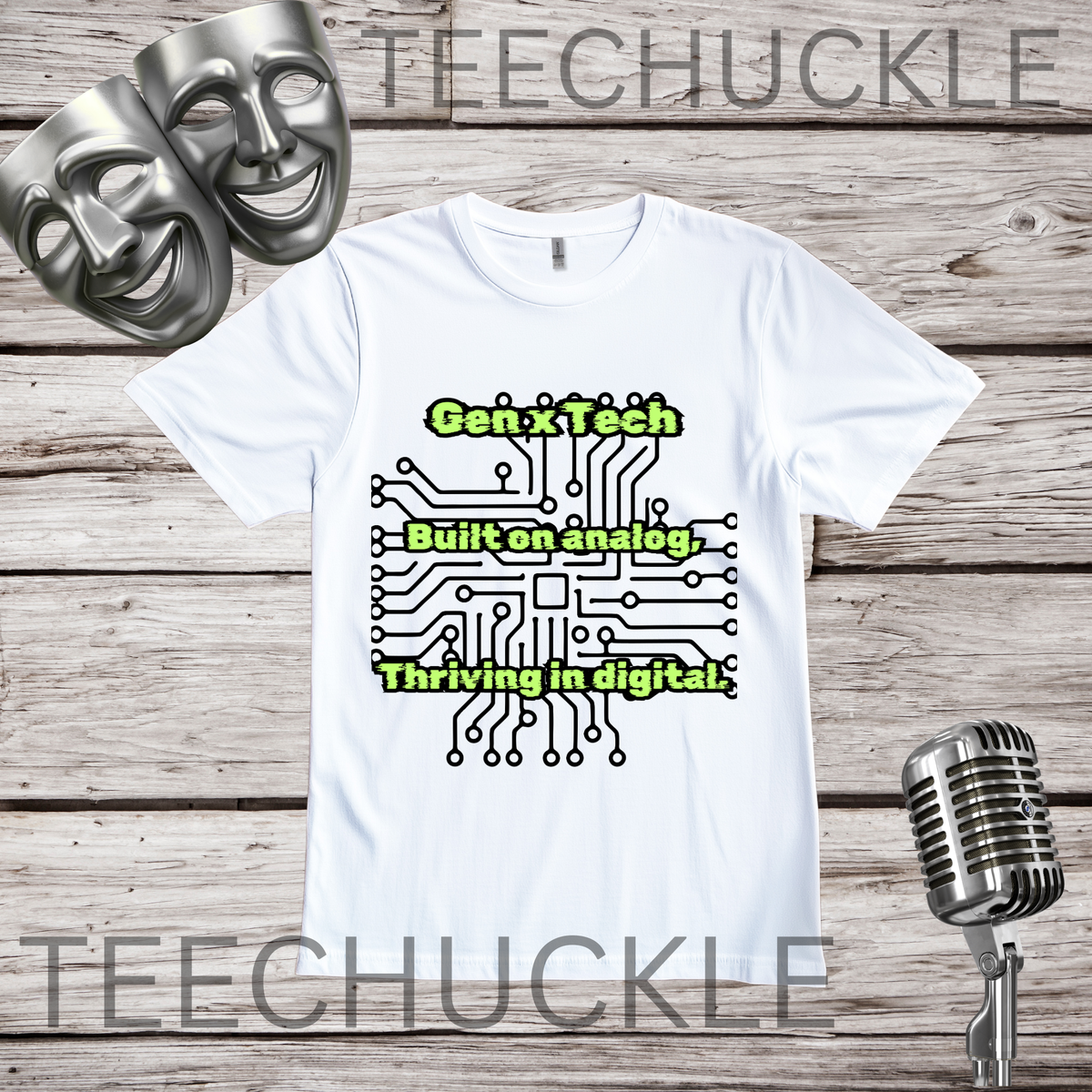 A white short-sleeve graphic T-shirt laid flat on a rustic wood background, with two silver comedy masks, a vintage microphone. The shirt has a circuit board graphic and text that reads "GEN X TECH, BUILT ON ANALOG, THRIVING IN DIGITAL". 
