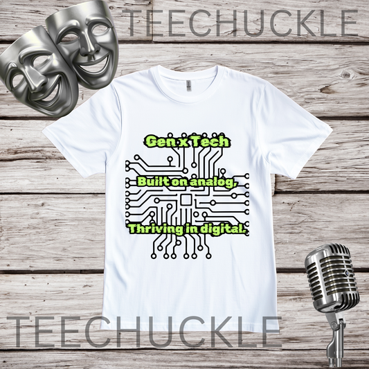 A white short-sleeve graphic T-shirt laid flat on a rustic wood background, with two silver comedy masks, a vintage microphone. The shirt has a circuit board graphic and text that reads "GEN X TECH, BUILT ON ANALOG, THRIVING IN DIGITAL". 