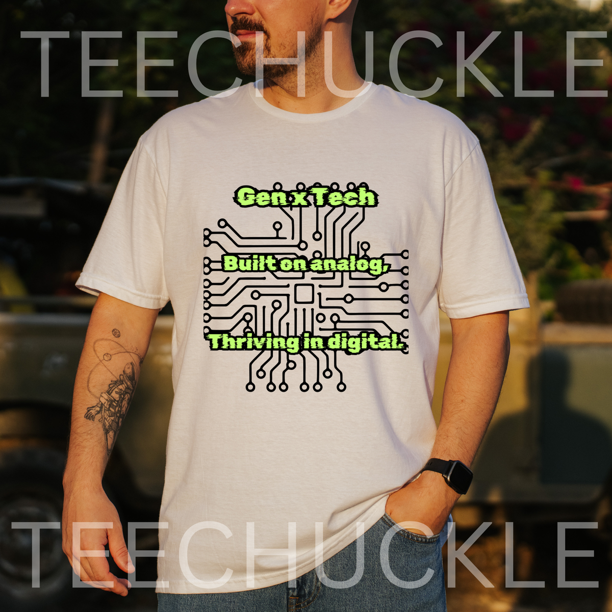 A man wearing a white graphic t-shirt with a black circuit board design and the text 'Gen x Tech, Built on analog, thriving in digital'