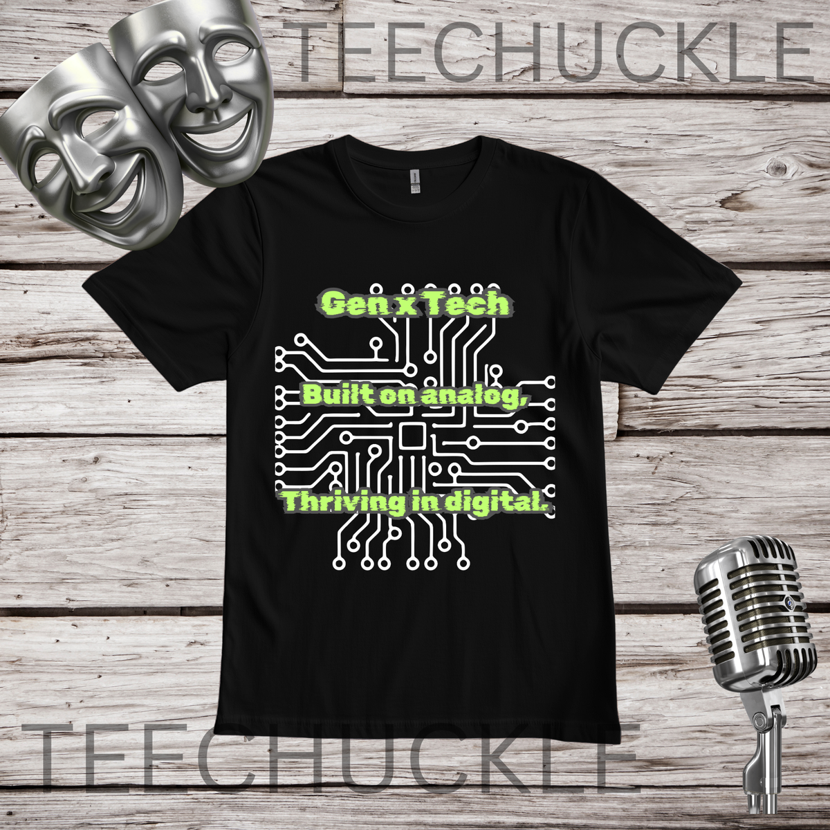 A black short-sleeve graphic t-shirt displayed flat on a rustic wood background, featuring a white circuit board with green text "GEN X TECH, BUILT ON ANALOG, THRIVING IN DIGITAL". The image includes decorative props like two silver theater masks, a vintage microphone.