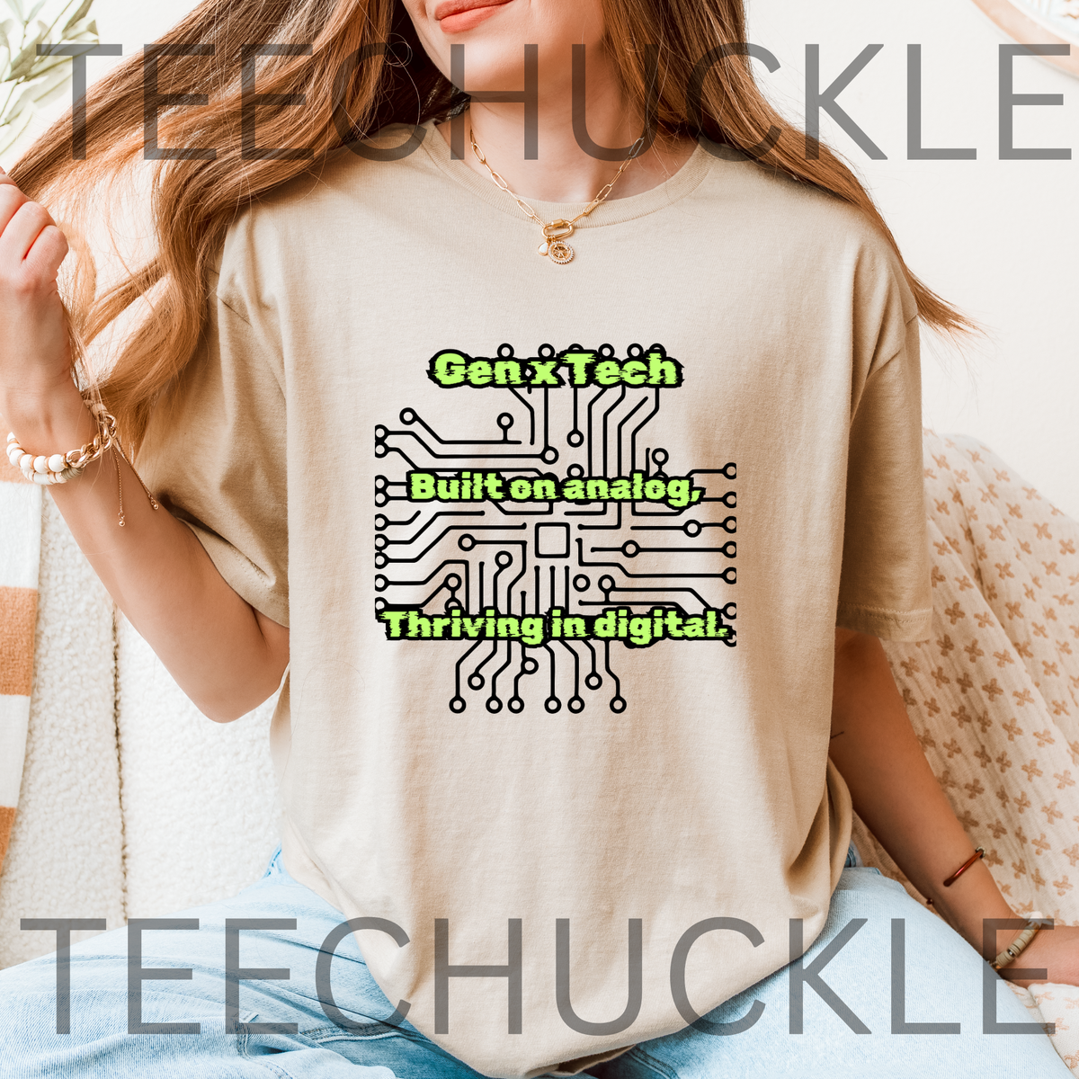 A woman wearing a sand graphic t-shirt with a black circuit board design and the text 'Gen X Tech Built on analog, Thriving in digital.