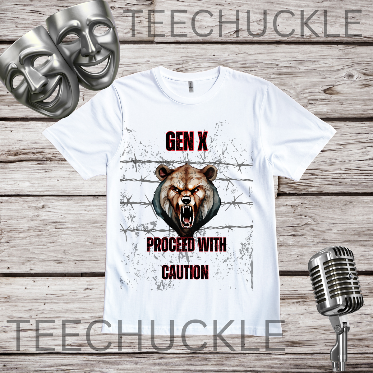 A white graphic t-shirt displayed on a rustic wood background, featuring a roaring bear illustration and the text 'GEN X PROCEED WITH CAUTION'. The shirt is accompanied by silver comedy masks and a vintage microphone prop.