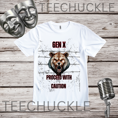 A white graphic t-shirt displayed on a rustic wood background, featuring a roaring bear illustration and the text 'GEN X PROCEED WITH CAUTION'. The shirt is accompanied by silver comedy masks and a vintage microphone prop.