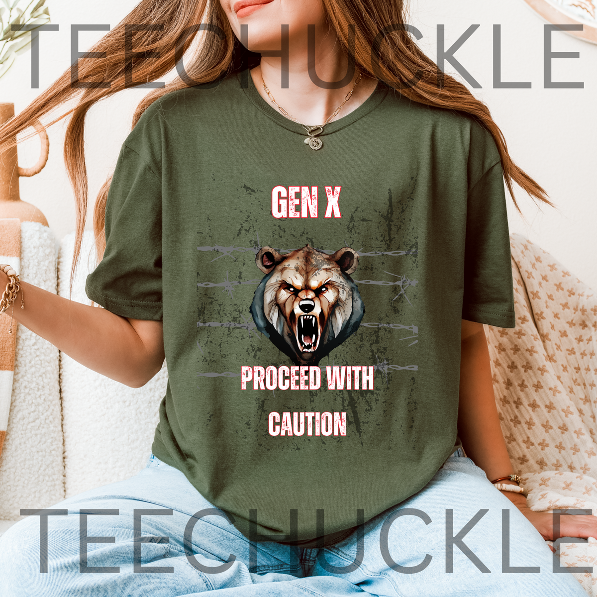 A woman sat wearing a green graphic t-shirt featuring a roaring bear illustration and the text 'GEN X PROCEED WITH CAUTION'. 