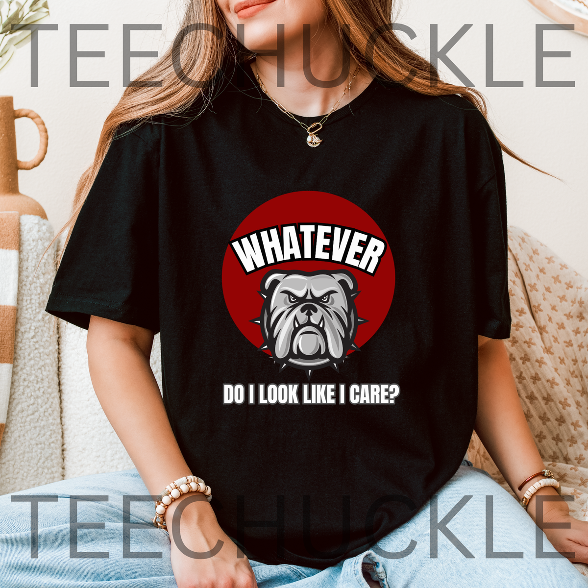 A woman wearing a black graphic t-shirt with a red circular bulldog design and the text 'WHATEVER DO I LOOK LIKE I CARE?'. 
