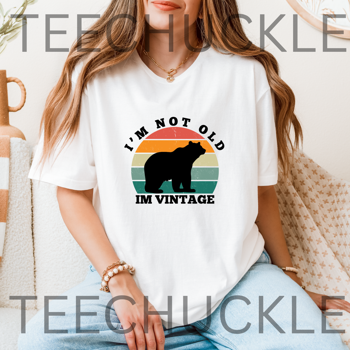 A woman wearing a white graphic t-shirt with a vintage-style bear design and the text 'I'M NOT OLD IM  VINTAGE'. 