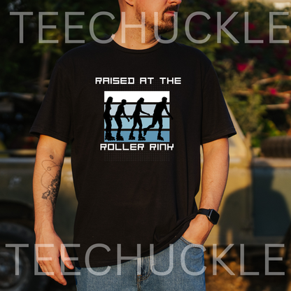 A man wearing a black graphic t-shirt with the text 'RAISED AT THE ROLLER RINK' and a roller rink silhouette graphic, set against an outdoor blurred background. 
