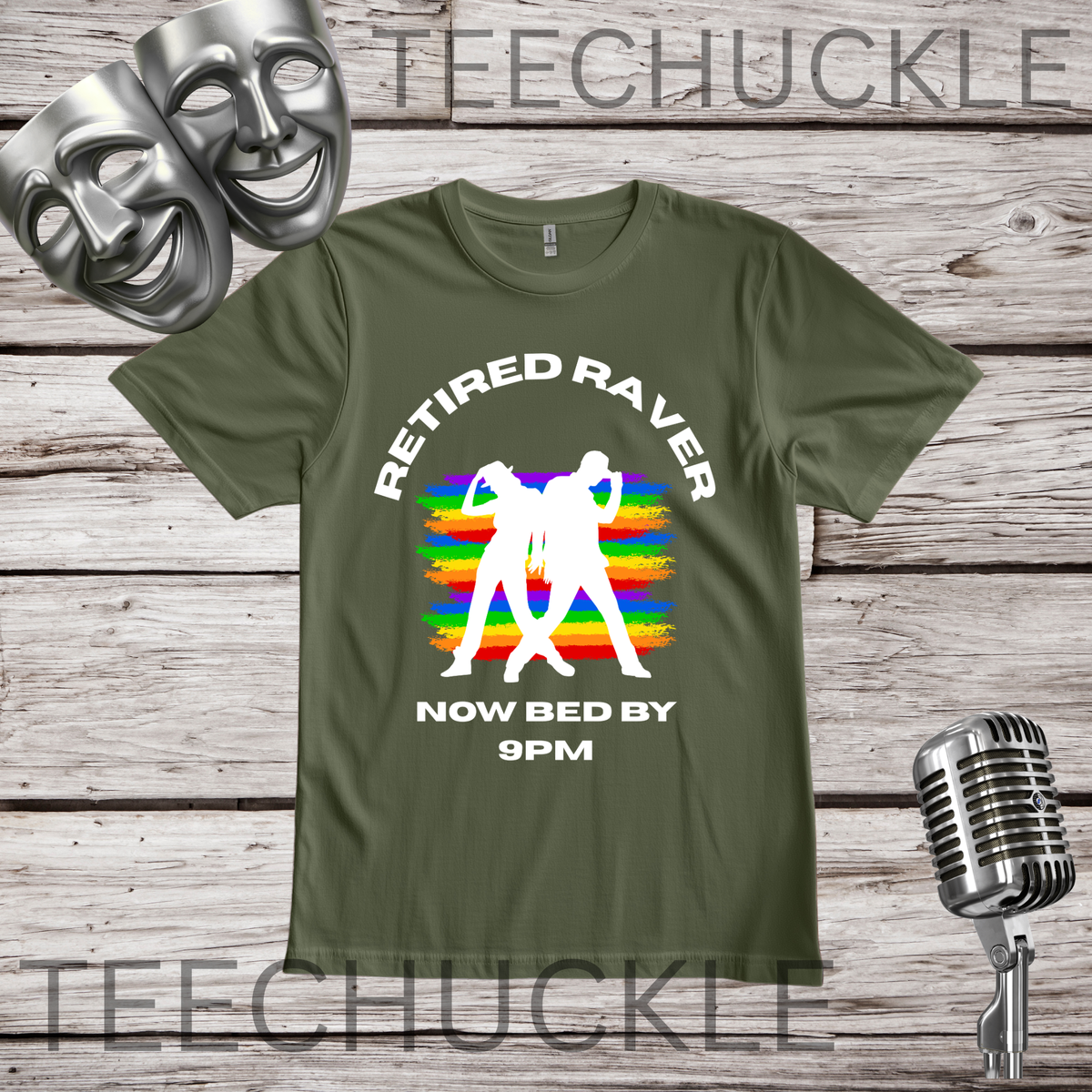 A green graphic t-shirt displayed on a rustic wooden background with vintage props including a silver microphone and theatrical masks. The t-shirt features a white graphic of a person dancing in front of a rainbow-striped sunset, with the text 'RETIRED RAVER NOW BED BY 9PM'.