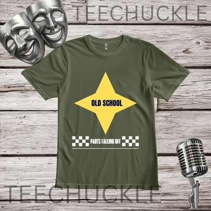 A green graphic t-shirt displayed on a rustic wooden background, styled with silver comedy masks, a vintage microphone. The t-shirt features a yellow star graphic with the text 'OLD SCHOOL' and a checkered bar below reading 'PARTS FALLING OFF'.
