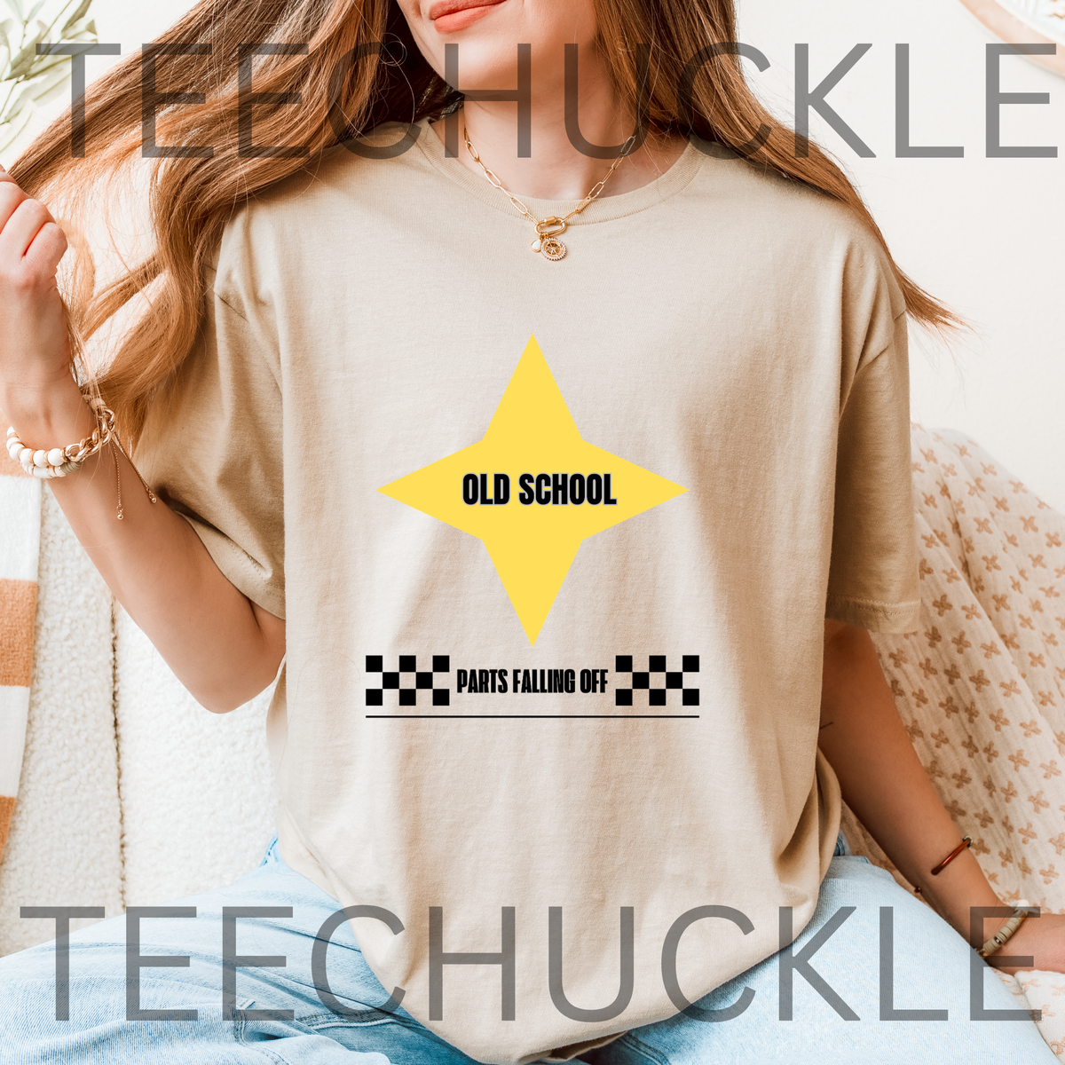 A woman wearing a sand graphic t-shirt with a yellow star and the text 'OLD SCHOOL' and 'PANTS FALLING OFF'.