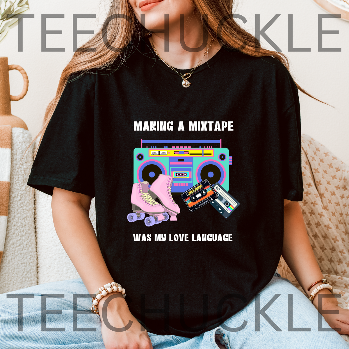 A woman wearing a black graphic t-shirt with a retro 80s boombox, roller skates, and cassette tapes design. The text reads 'MAKING A MINTAPE WAS MY LOVE LANGUAGE'.