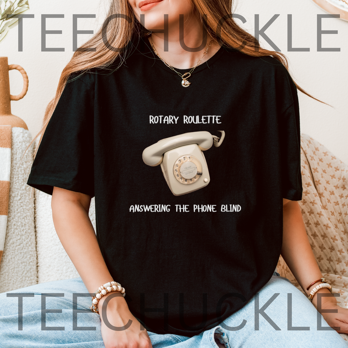 A woman wearing a black graphic t-shirt with a retro rotary phone design and the text 'ROTARY ROULETTE' and 'ANSWERING THE PHONE BLIND'.