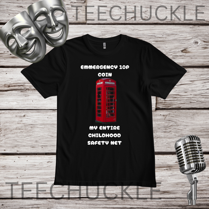 A black short-sleeve graphic T-shirt laid flat on a rustic wood plank background, with two silver theater masks, a vintage microphone. The shirt graphic shows a red telephone booth and white text reading 'EMERGENCY 109 COIN MY ENTIRE CHILDHOOD SAFETY NET'.