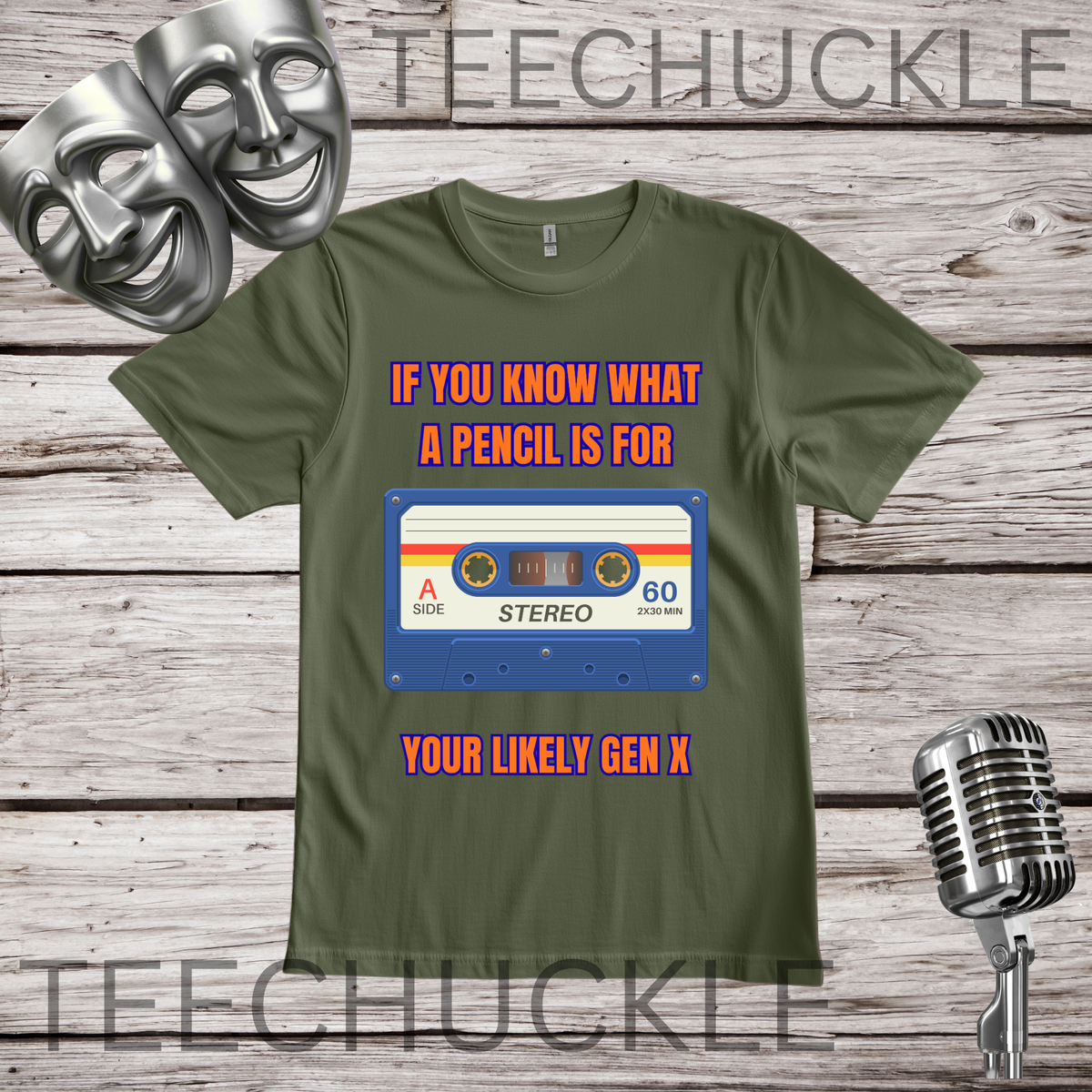 A green graphic t-shirt displayed on a rustic wood background, featuring a retro cassette tape design with the text 'IF YOU KNOW WHAT A PENCIL IS FOR YOUR LIKELY GEN X'. The image includes decorative props like two silver comedy masks and a vintage microphone