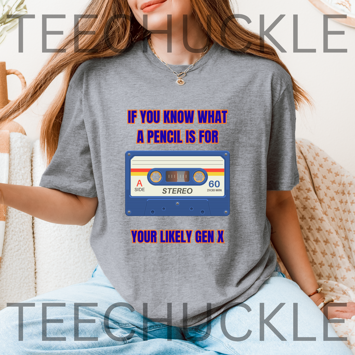 A woman wearing a heather gray graphic t-shirt with a retro cassette tape design and the text 'IF YOU KNOW WHAT A PENCIL IS FOR YOUR LIKELY GEN X'. 