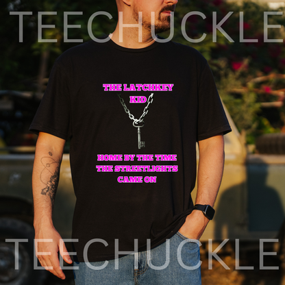 A man wearing a black graphic t-shirt with a pink and white design that reads 'TIME LATCHKEY KID' and 'HOME BY THE TIME THE STREETLIGHTS GAME ON'. The background is a blurred outdoor setting with a vehicle