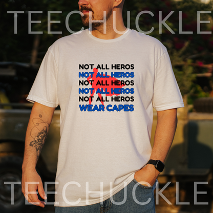 A man wearing a white graphic t-shirt with the text 'NOT ALL HEROS' repeated in black and blue, with a red superhero, and finished with 'WEAR CAPES' in blue. 
