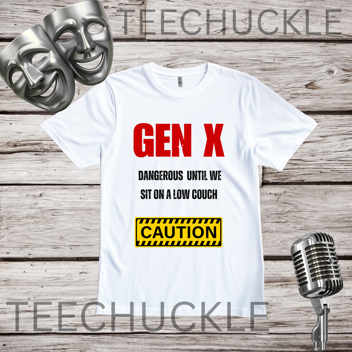 A white t-shirt displayed on a rustic wood background, featuring a red and black text design that reads 'GEN X DANGEROUS UNTIL WE SIT ON A LOW COUCH' with a yellow caution box below. Two silver comedy masks are on the top left, and a vintage silver microphone is on the bottom right.