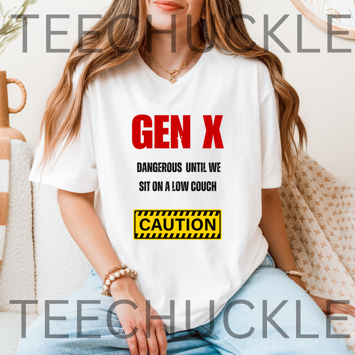 A woman wearing a white graphic t-shirt with the text 'GEN X DANGEROUS UNTIL WE SIT ON A LOW COUCH' and a yellow 'CAUTION' box graphic. 