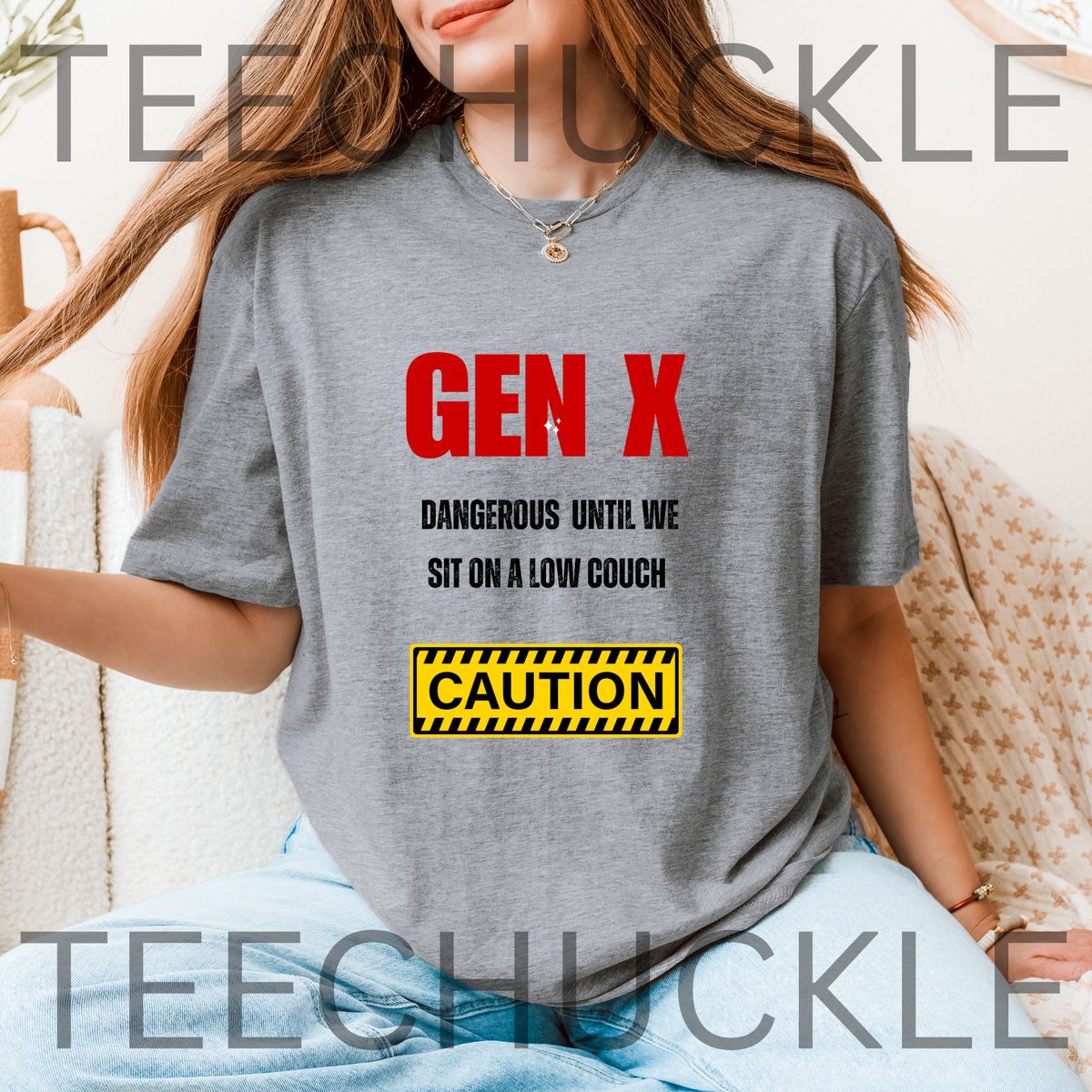 A woman wearing a gray graphic t-shirt with the text 'GEN X DANGEROUS UNTIL WE SIT ON A LOW COUCH' in red and black, and a yellow 'CAUTION' sign graphic.