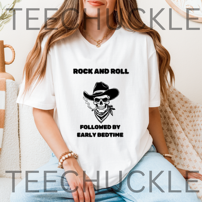 A woman wearing a white graphic t-shirt with a black skull in a cowboy hat design and the text 'ROCK AND ROLL FOLLOWED BY EARLY BEDTIME' and is set in a cozy indoor environment.