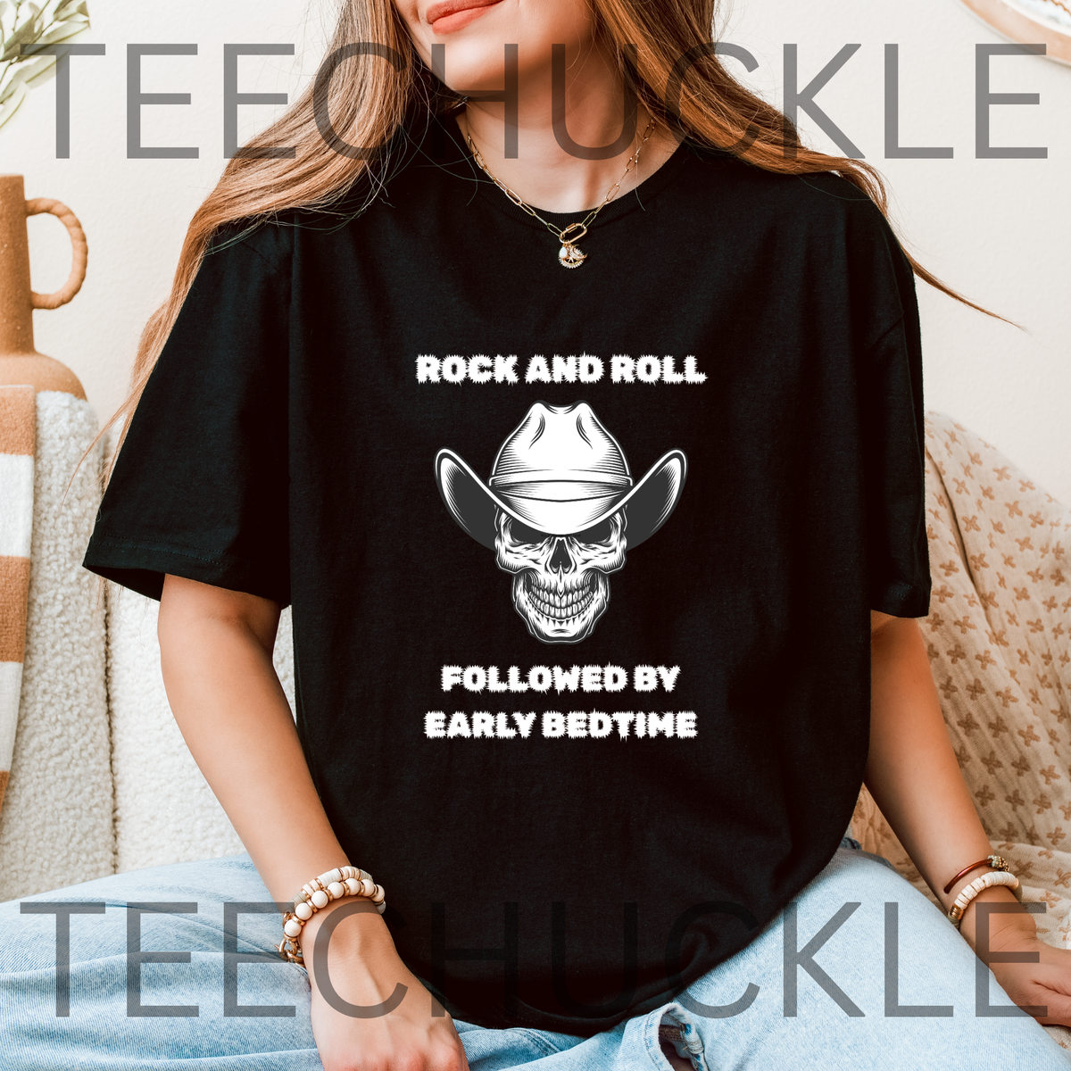 A woman wearing a black graphic t-shirt with a white western skull design and the text 'ROCK AND ROLL FOLLOWED BY EARLY BEDTIME'. 