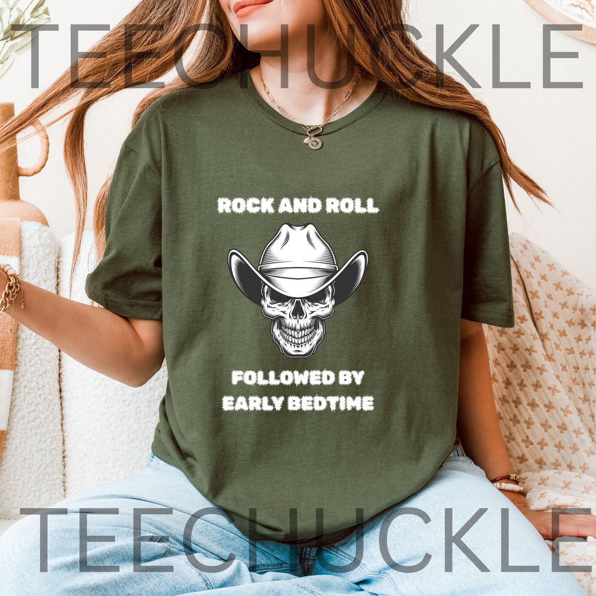 A woman wearing an green graphic t-shirt with a white skull wearing a cowboy hat and the text 'ROCK AND ROLL FOLLOWED BY EARLY BEDTIME'. 