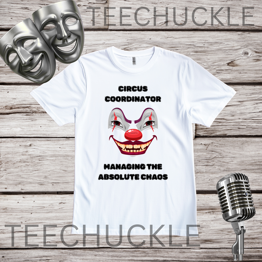 A white graphic t-shirt featuring a creepy clown face and the text 'CIRCUS COORDINATOR' and 'MANAGING THE ABSOLUTE CHAOS' in black. The t-shirt is displayed on a rustic wood background with silver theater-themed props (a comical mask and a vintage microphone) and a prominent 'TEECHUCKLE' watermark overlay.