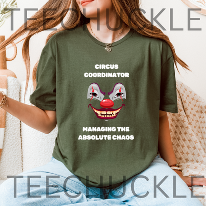 A woman wearing an green graphic t-shirt with a creepy clown face and the text 'CIRCUS COORDINATOR' and 'MANAGING THE ABSOLUTE CHAOS'.