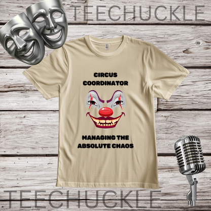 A sand graphic t-shirt featuring a clown face and the text 'CIRCUS COORDINATOR' and 'MANAGING THE ABSOLUTE CHAOS' on a rustic wood plank background, styled with theatrical masks, a vintage microphone