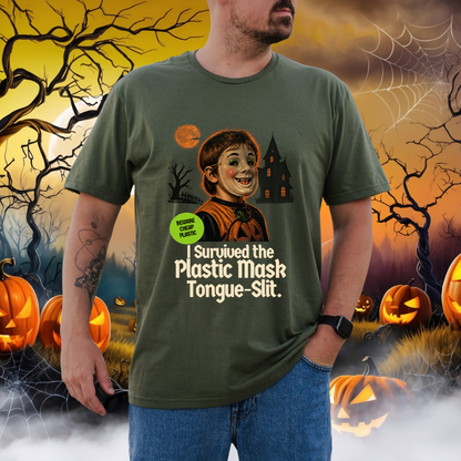 A man wearing a green graphic t-shirt with a Halloween-themed print of a plastic-mouth mask character, set against a spooky Halloween background with pumpkins and bare trees.