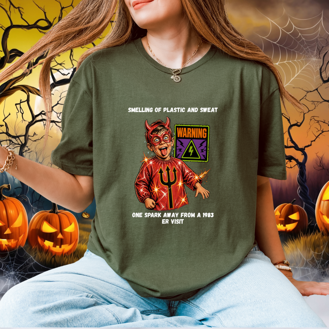 A woman wearing a green graphic t-shirt with a devil-themed Halloween print and humourous text , set against a spooky Halloween-themed background with pumpkins and cobwebs.