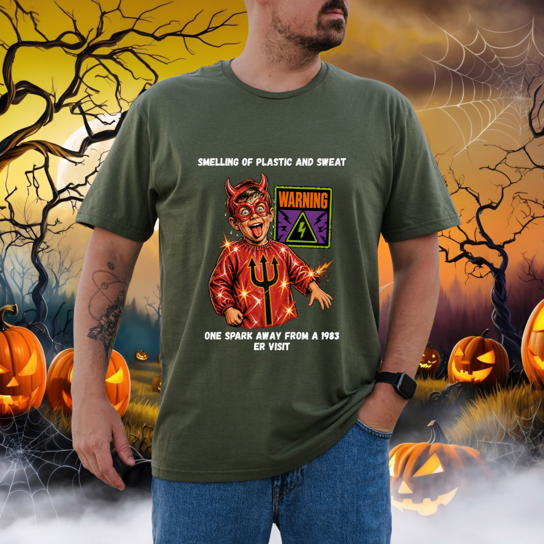 A man wearing a green graphic t-shirt with a devil design and text, set against a Halloween-themed background with pumpkins, cobwebs, and a spooky sky.