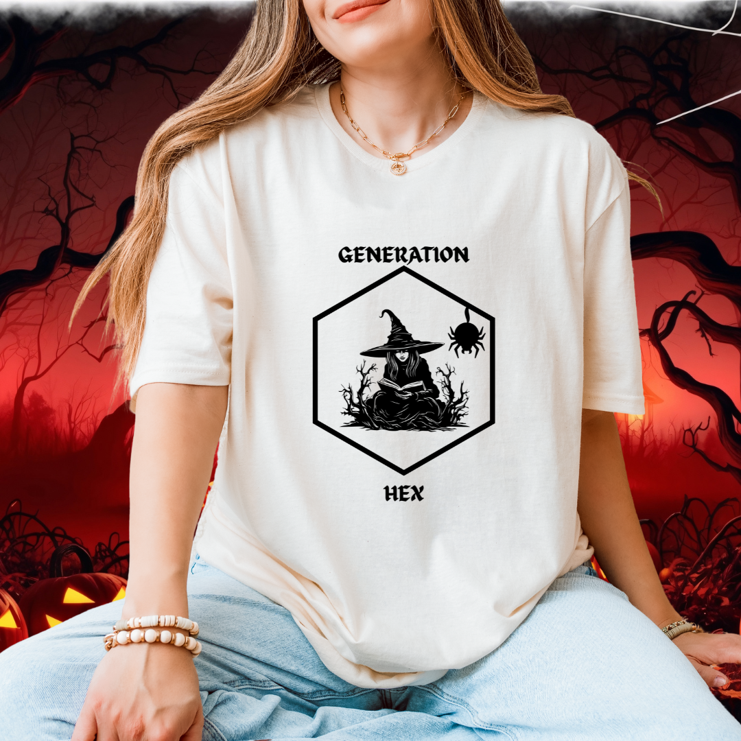 A woman wearing a cream-colored graphic t-shirt with a black witch-themed design that reads 'GENERATION HEX'. The background is a spooky, dark red Halloween-themed scene with silhouettes of trees and jack-o'-lanterns.