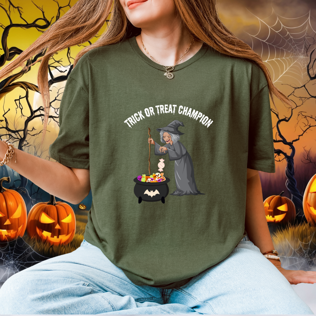 A woman wearing a green graphic t-shirt with a 'Trick or Treat Champion' witch and cauldron design, set against a Halloween-themed background with pumpkins and cobwebs.