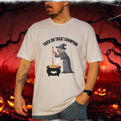 A man wearing a white graphic t-shirt with a Halloween witch design and the text 'TRICK OR TREAT CHAMPION'. The background is a spooky red-toned Halloween scene with pumpkins and bare trees.