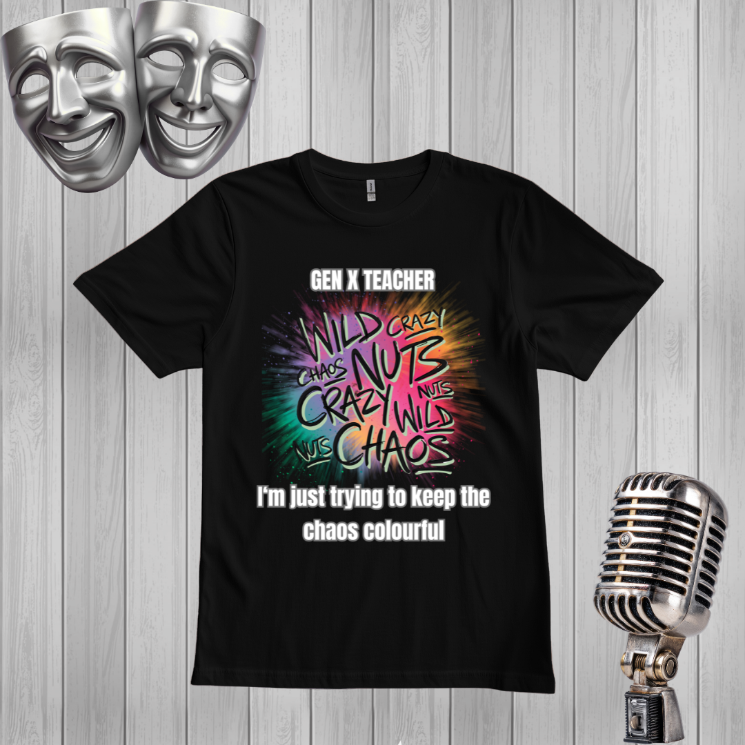 A black short-sleeve graphic T-shirt displayed on a light gray wood plank background, with two silver comedy masks in the top left and a vintage silver microphone in the bottom right. The shirt features a colorful tie-dye style graphic with the text 'GEN X TEACHER', 'WILD CRAZY', 'CRAZY NUTS', 'MILD CHAOS', and 'I'm just trying to keep the chaos colourful'.