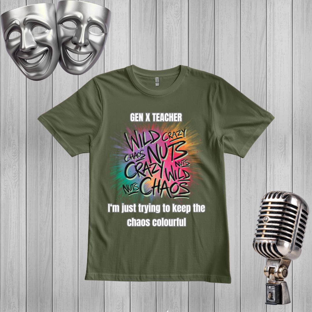A green graphic t-shirt displayed on a light gray wood plank background, styled with two silver comedy masks in the top-left corner and a vintage silver microphone on the right. The t-shirt features a colorful retro-style graphic with the text 'GEN X TEACHER' and 'I'm just trying to keep the chaos colourful'.