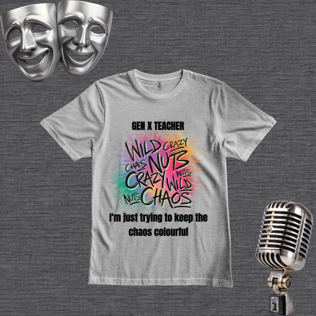 A lgray graphic t-shirt displayed on a dark gray textured background, styled with silver comedy masks in the top-left corner and a vintage silver microphone in the bottom-right corner. The t-shirt features a colorful, hand-drawn style graphic with the words 'WILD CRAZY CHAOS NUTS' in various colors, with 'GEN X TEACHER' above and 'I'm just trying to keep the chaos colourful' below.