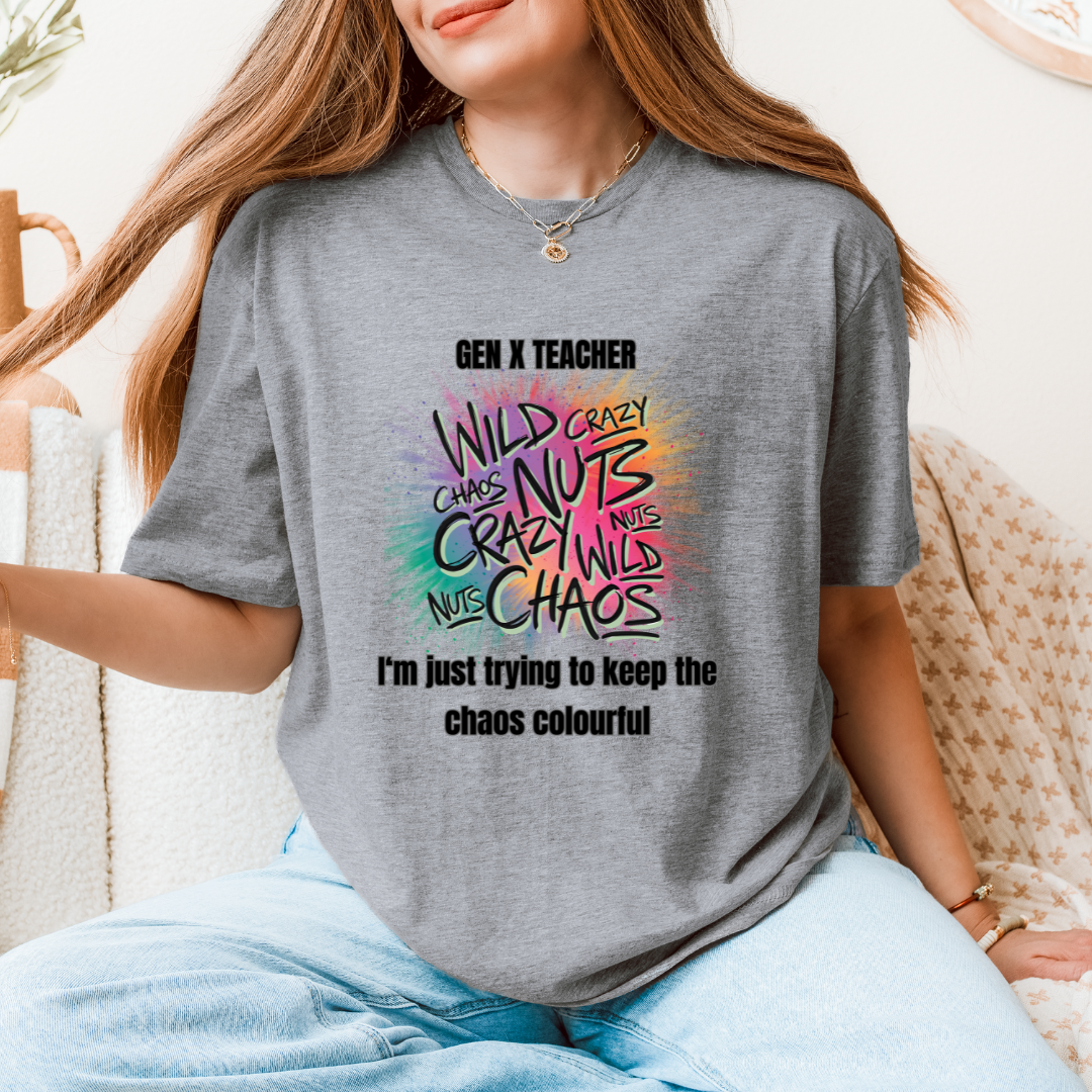 A woman wearing agray graphic t-shirt with a colorful text design that reads 'GEN X TEACHER WILD CRAZY NUTS NUCLE CHAOS' and 'I'm just trying to keep the chaos colourful'.