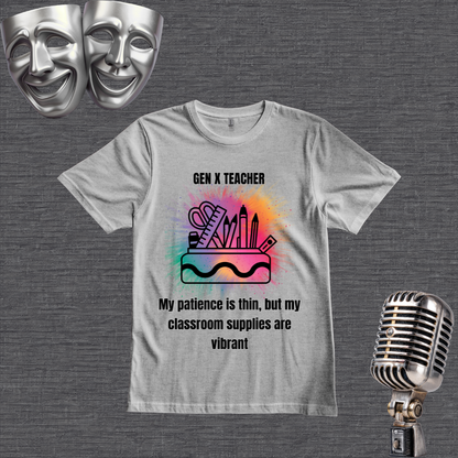 A gray graphic t-shirt displayed on a dark gray textured background, styled with two silver comedy masks in the top-left corner and a vintage silver microphone in the bottom-right corner. The t-shirt features a colorful watercolor-style illustration of school supplies (ruler, scissors, pencils, eraser) with the text 'GEN X TEACHER My patience is thin, but my classroom supplies are vibrant'.