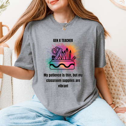 A woman wearing a gray graphic t-shirt with a colorful classroom supplies design and the text 'GEN X TEACHER My patience is thin, but my classroom supplies are vibrant'.
