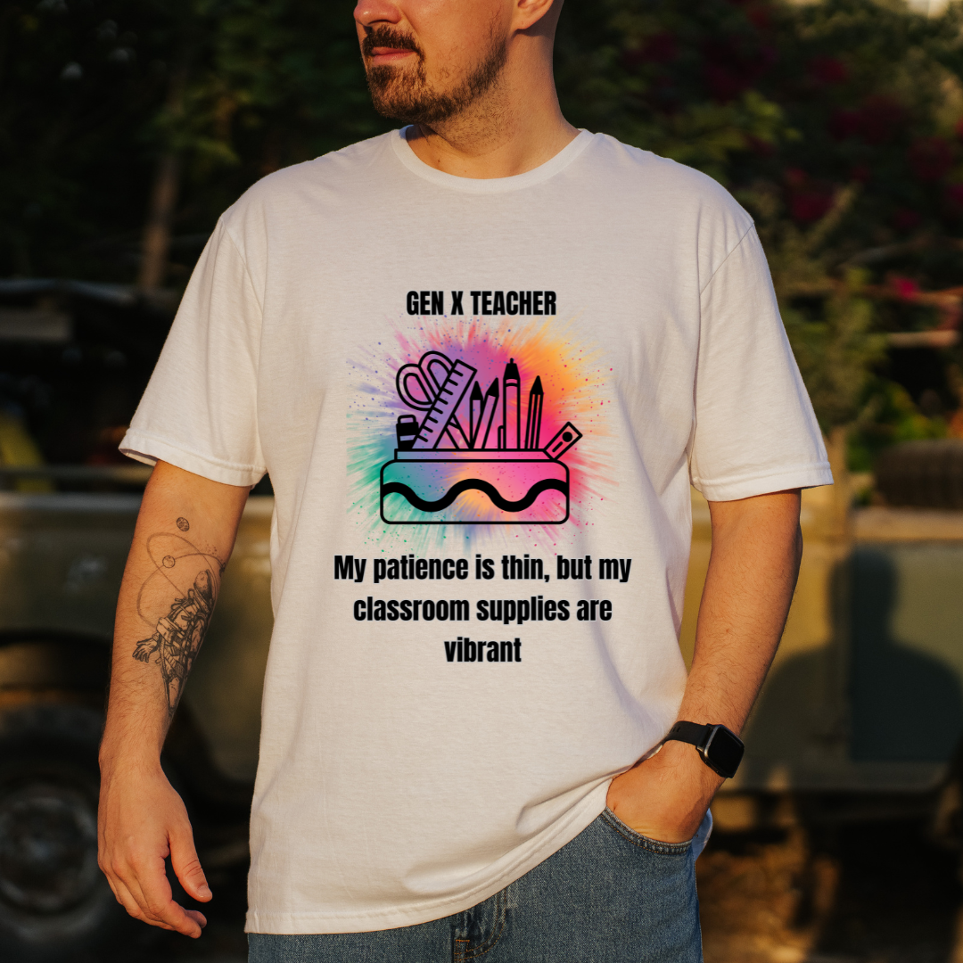 A man wearing a white graphic t-shirt with a colorful paint-splatter design and the text 'GEN X TEACHER My patience is thin, but my classroom supplies are vibrant'.