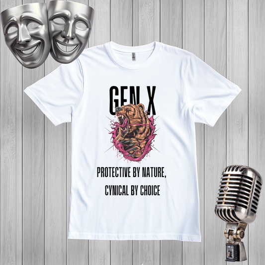A white short-sleeve graphic T-shirt laid flat on a gray wood plank background, with a printed design featuring the text 'GEN X' above a roaring bear bursting through a pink circular graphic, and the phrase 'PROTECTIVE BY NATURE, CYNICAL BY CHOICE' below. Silver theatrical masks appear in the top left, and a vintage-style microphone appears in the bottom right.