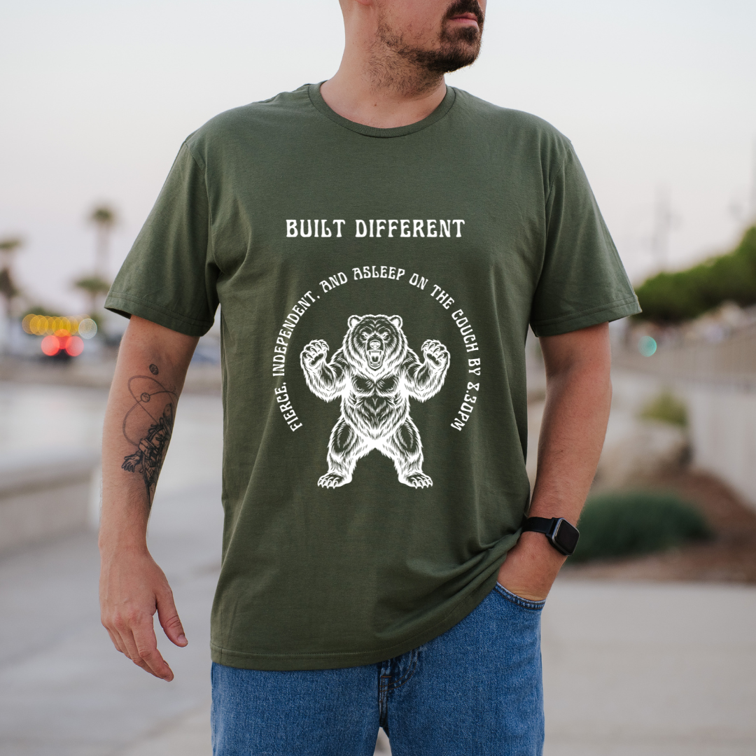 A man wearing a green t-shirt with a white graphic of a muscular bear and the text 'BUILT DIFFERENT' 